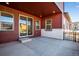 An outdoor patio featuring a sliding glass door, multiple windows, and a brick facade at 17822 E 107Th Pl, Commerce City, CO 80022
