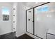 Bright bathroom showcasing a glass shower door with black trim and a window with neighborhood views at 17822 E 107Th Pl, Commerce City, CO 80022