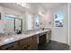 Bathroom features a large mirror, granite counters, dual sinks, and a shower with glass door at 17822 E 107Th Pl, Commerce City, CO 80022