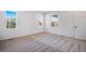 Bright bedroom with neutral carpet, white walls, and two windows at 17822 E 107Th Pl, Commerce City, CO 80022