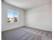 Bright bedroom with neutral carpet with a large window offering neighborhood views at 17822 E 107Th Pl, Commerce City, CO 80022