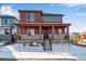 Charming two-story home with a covered porch, gray railings, and a well-maintained front yard with minimal snow at 17822 E 107Th Pl, Commerce City, CO 80022