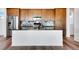 Contemporary kitchen island with black countertop, wood cabinets, and stainless steel appliances at 17822 E 107Th Pl, Commerce City, CO 80022