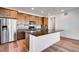 Close up of the modern kitchen with a large island, stainless steel appliances, and wood cabinets at 17822 E 107Th Pl, Commerce City, CO 80022
