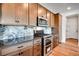 Well-lit kitchen features stainless steel appliances, modern cabinets, and black and white marble backsplash at 17822 E 107Th Pl, Commerce City, CO 80022