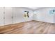 Bright living room with light wood floors, white walls, large windows, and a minimalist design at 17822 E 107Th Pl, Commerce City, CO 80022