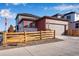 Rear view of a modern home with a two-car garage and fenced backyard with professional landscaping at 17822 E 107Th Pl, Commerce City, CO 80022