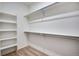Carpeted walk-in closet features built-in shelving and metal rods for hanging clothes at 17822 E 107Th Pl, Commerce City, CO 80022