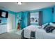 Vibrant blue bedroom with a cozy seating area and modern fixtures at 10265 Olathe St, Commerce City, CO 80022