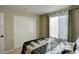 Well-lit bedroom featuring a window with sheer curtains and convenient closet with sliding doors at 10265 Olathe St, Commerce City, CO 80022