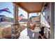 Inviting front porch showcasing a cozy swing and stone pillar accents at 10265 Olathe St, Commerce City, CO 80022