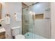 Bathroom featuring a glass shower with shelving, neutral tile, and modern gold fixtures at 921 Meade St, Denver, CO 80204