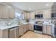 Modern kitchen featuring stainless steel appliances, light wood cabinets, quartz countertops and designer backsplash at 921 Meade St, Denver, CO 80204