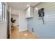 Bright laundry room with sleek cabinets, modern blue-grey shiplap wall, and a practical design for easy chores at 921 Meade St, Denver, CO 80204