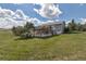 Spacious backyard showcasing a covered patio, a lush lawn, mature trees and a view of the home's rear exterior at 2996 Savage Rd, Elizabeth, CO 80107