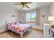 Bedroom with carpeted floors, large window, ceiling fan, neutral paint, and a bed with colorful patchwork quilt at 2996 Savage Rd, Elizabeth, CO 80107