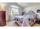 Cozy bedroom with neutral walls, a large window, carpeted floors, and a bed with a gray, tufted headboard at 2996 Savage Rd, Elizabeth, CO 80107