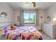 Bedroom with carpeted floors, large window, ceiling fan, neutral paint, and a bed with colorful patchwork quilt at 2996 Savage Rd, Elizabeth, CO 80107