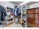 Walk-in closet with built-in white shelves and drawers plus a wooden dresser with a variety of clothes and storage at 2996 Savage Rd, Elizabeth, CO 80107