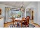 The dining room has hardwood floors, a large window, a wooden dining table and a modern light fixture at 2996 Savage Rd, Elizabeth, CO 80107