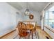 The dining room has hardwood floors, a large window, a wooden dining table and a modern light fixture at 2996 Savage Rd, Elizabeth, CO 80107