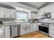 Bright kitchen featuring white cabinets, stainless steel appliances, and scenic window view at 2996 Savage Rd, Elizabeth, CO 80107