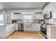 Well-lit kitchen with white cabinets, stainless steel appliances, and a large window at 2996 Savage Rd, Elizabeth, CO 80107