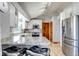 Bright kitchen features white cabinetry, stainless steel appliances, granite countertops, and a vaulted ceiling at 2996 Savage Rd, Elizabeth, CO 80107