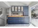 Stylish kitchen area with navy cabinetry, wine cooler and access to the outdoor living space at 1292 W 133Rd Cir, Westminster, CO 80234