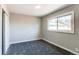 Spacious bedroom with grey carpet and large window at 7780 Hollywood St, Commerce City, CO 80022