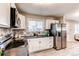 Modern kitchen with white cabinets, stainless steel appliances, and patterned backsplash at 7780 Hollywood St, Commerce City, CO 80022