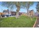 Spacious backyard offers a playset, tall trees, and outdoor seating on a well-maintained lawn at 1655 S Lowell Blvd, Denver, CO 80219