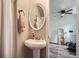 Elegant half bath featuring a pedestal sink, stylish mirror, and convenient accessories at 1655 S Lowell Blvd, Denver, CO 80219