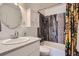 Well-maintained bathroom with pebble accent wall, modern fixtures, and a bathtub at 1655 S Lowell Blvd, Denver, CO 80219