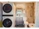 Bathroom featuring stacked washer and dryer, vanity, and tiled shower with modern fixtures at 1655 S Lowell Blvd, Denver, CO 80219