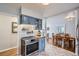 Modern kitchen features stainless steel appliances, blue cabinets, and stylish tile backsplash at 1655 S Lowell Blvd, Denver, CO 80219