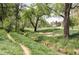 Scenic park view with lush greenery, mature trees, and walking path along a creek at 1655 S Lowell Blvd, Denver, CO 80219