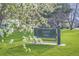 Welcome to Harvey Park sign surrounded by green lawns and flowering trees at 1655 S Lowell Blvd, Denver, CO 80219