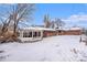 Snow-covered backyard with a brick house and gazebo at 4730 Carr St, Wheat Ridge, CO 80033