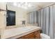 Cozy bathroom featuring a shower with tub and a functional vanity area with mirror and light fixtures at 12963 Silver Elk Ln, Littleton, CO 80127