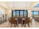 Elegant dining area with large table, seating for eight, chandelier lighting and mountain views through large sliding doors at 12963 Silver Elk Ln, Littleton, CO 80127
