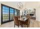 Elegant dining room with view, featuring chandeliers, a large wood table, and sliding doors to a patio at 12963 Silver Elk Ln, Littleton, CO 80127
