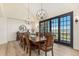 Formal dining room with a large wood table, seating for ten, elegant chandeliers, and sliding patio doors at 12963 Silver Elk Ln, Littleton, CO 80127