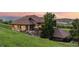 Charming home featuring a stone and stucco exterior, a clay tile roof, and a landscaped lawn at 12963 Silver Elk Ln, Littleton, CO 80127