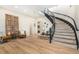 Bright foyer features a curved staircase, light wood floors, and an indoor fountain feature at 12963 Silver Elk Ln, Littleton, CO 80127