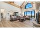 Spacious living room features high ceilings, wood beams, large windows with mountain views and a brown leather sectional at 12963 Silver Elk Ln, Littleton, CO 80127