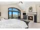 Main bedroom showcasing a fireplace, vaulted ceiling, and large windows with scenic views at 12963 Silver Elk Ln, Littleton, CO 80127