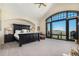 Spacious main bedroom featuring a dark wood bed frame, vaulted ceiling, and large windows offering scenic views at 12963 Silver Elk Ln, Littleton, CO 80127