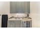 Charming wet bar area featuring custom gray cabinets, a sink, and a beverage refrigerator at 12963 Silver Elk Ln, Littleton, CO 80127