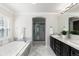Bright bathroom features a soaking tub, glass enclosed shower, and dual sink vanity with granite counters at 16376 Stonefeld Pl, Parker, CO 80134